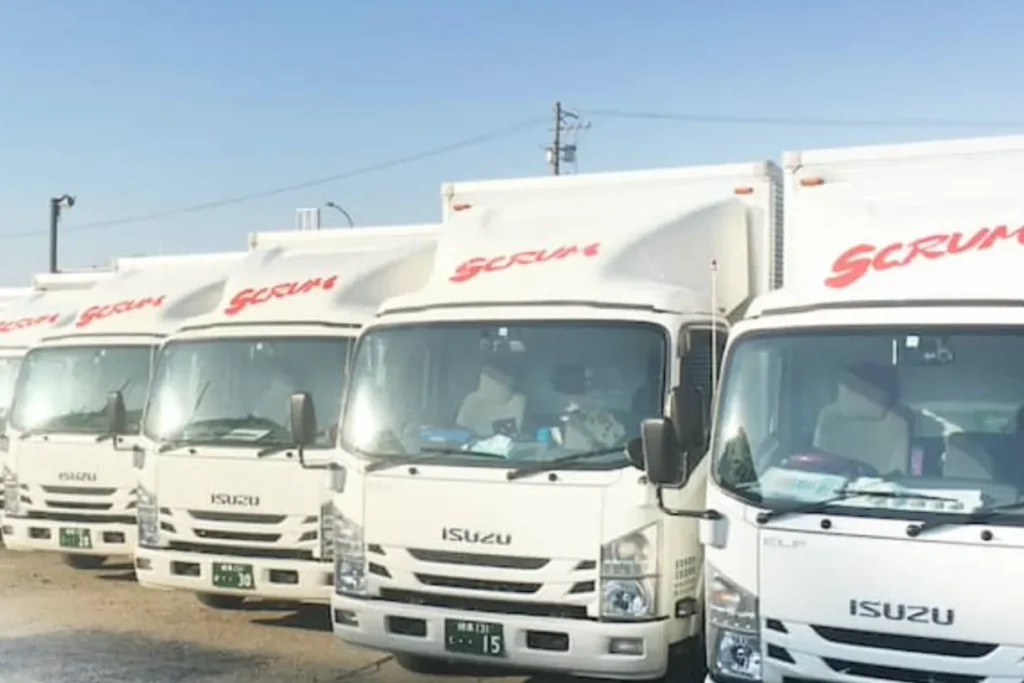 運送会社のトラックが並ぶ物流拠点のイメージ